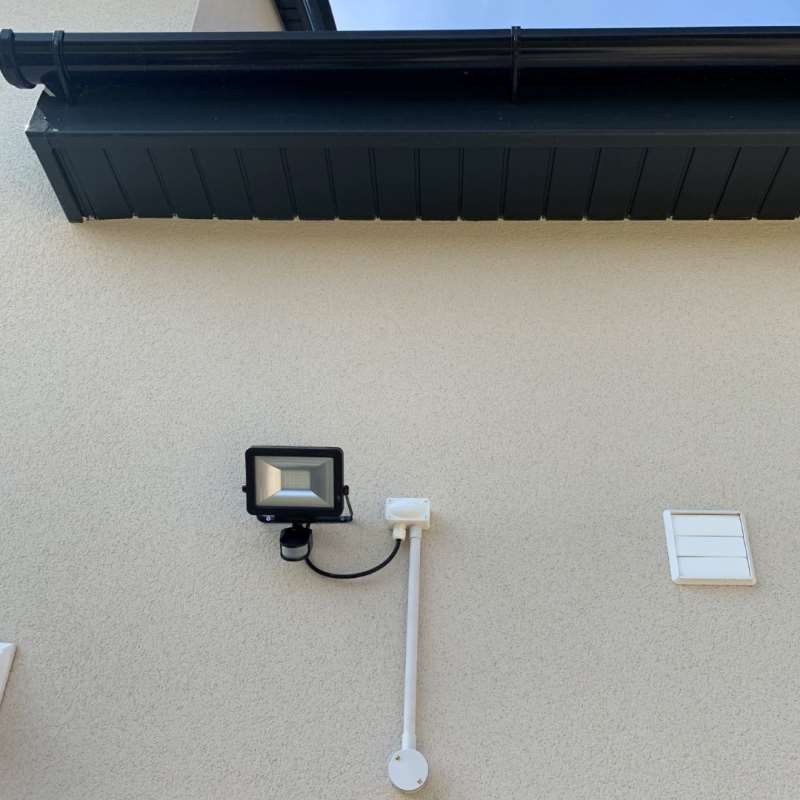 Outdoor floodlight with PIR sensor fitted to a house wall